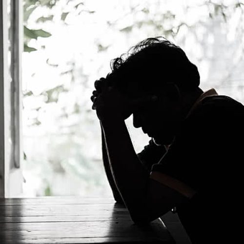pngtree-a-miserable-man-with-his-head-bowed-down-in-despair-sitting-in-dimly-lit-darkness-photo-image_30916280
